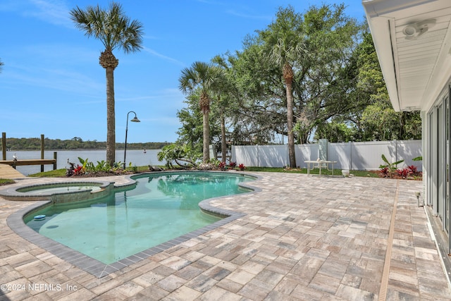 view of pool with a patio, an in ground hot tub, and a water view