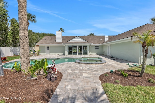 view of swimming pool featuring a patio area and an in ground hot tub