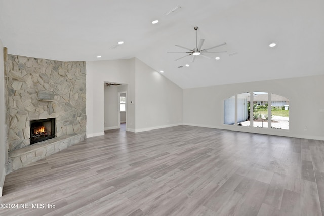 unfurnished living room featuring ceiling fan, light hardwood / wood-style flooring, a fireplace, and vaulted ceiling