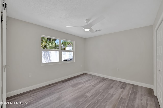 spare room featuring hardwood / wood-style floors, ceiling fan, and a textured ceiling