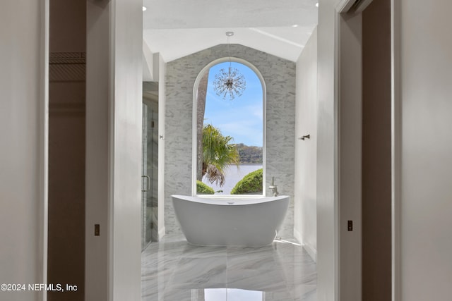 bathroom featuring lofted ceiling, tile walls, tile floors, and a bathtub