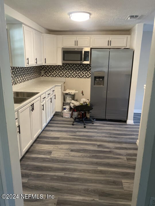 kitchen with backsplash, stainless steel appliances, dark wood-type flooring, white cabinetry, and sink