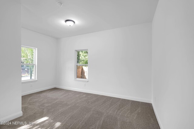 unfurnished room with dark colored carpet