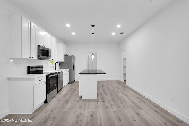 kitchen with light hardwood / wood-style floors, stainless steel appliances, and white cabinets