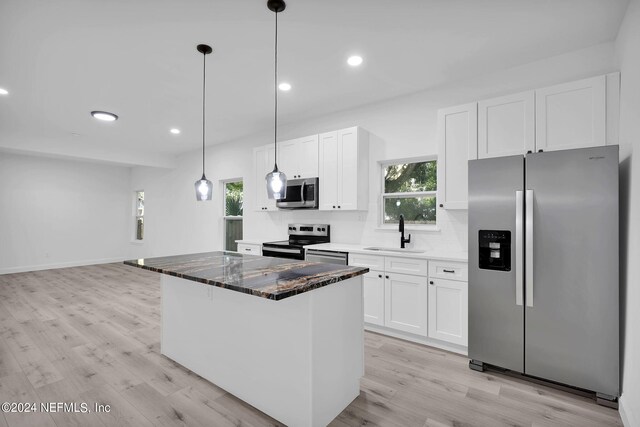 kitchen with white cabinets, backsplash, stainless steel appliances, sink, and light hardwood / wood-style floors