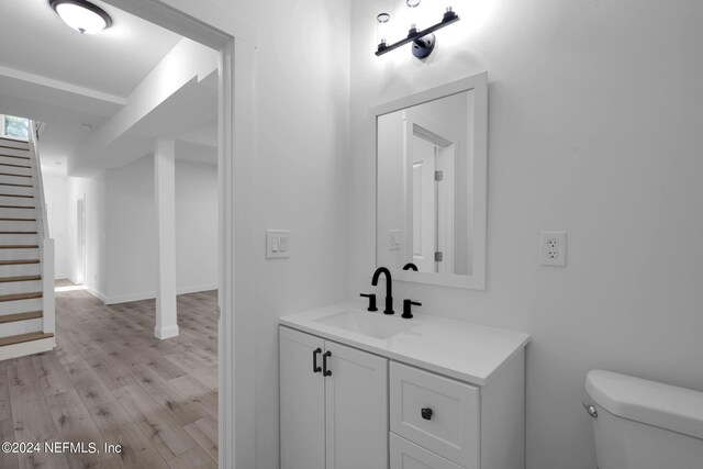 bathroom featuring hardwood / wood-style flooring, toilet, and large vanity