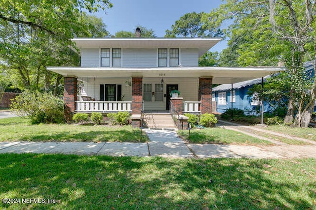 view of front facade with a carport, a porch, and a front lawn