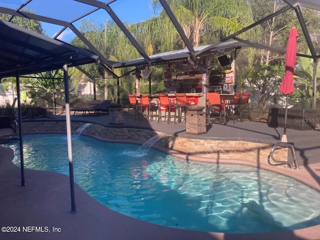 view of pool with a lanai, pool water feature, and a patio area