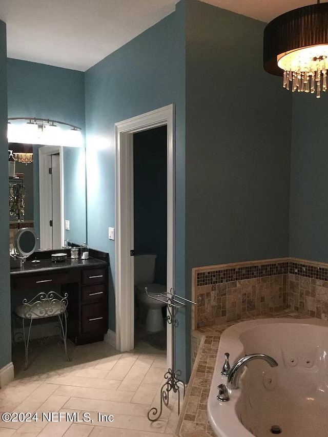 bathroom with tile floors, toilet, vanity with extensive cabinet space, and a washtub