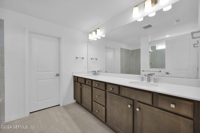 bathroom featuring vanity, a shower, and tile patterned floors