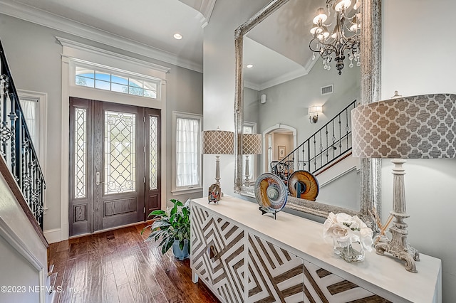 entrance foyer featuring a healthy amount of sunlight, crown molding, dark hardwood / wood-style floors, and a high ceiling