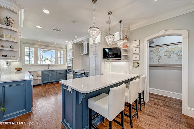 kitchen featuring decorative light fixtures, backsplash, a breakfast bar area, dark hardwood / wood-style floors, and sink