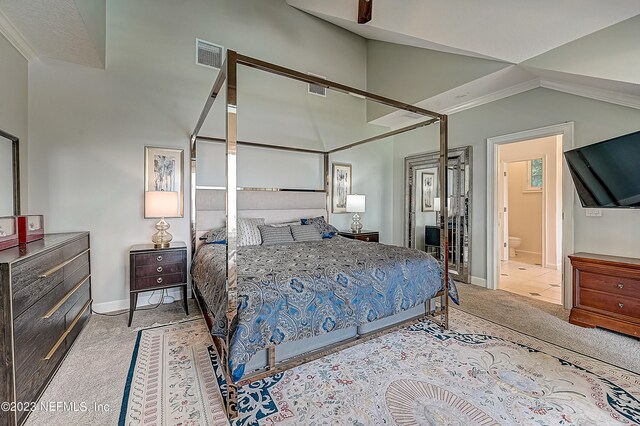 bedroom featuring light colored carpet, ceiling fan, and ensuite bathroom