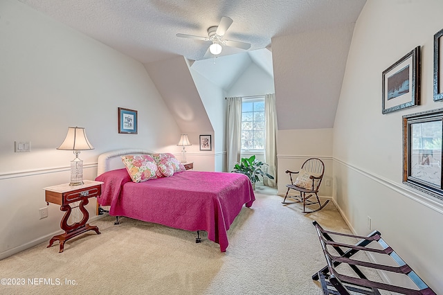 bedroom featuring lofted ceiling, ceiling fan, carpet floors, and a textured ceiling