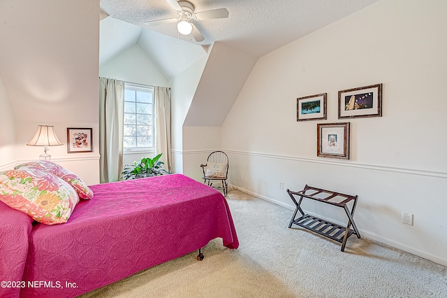 carpeted bedroom with a textured ceiling, ceiling fan, and vaulted ceiling