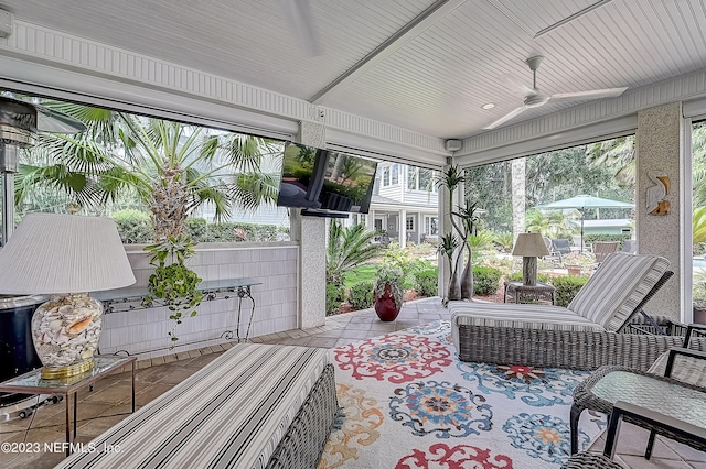 sunroom / solarium featuring ceiling fan