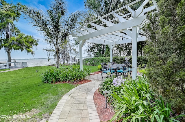 view of property's community featuring a patio, a yard, a water view, and a pergola