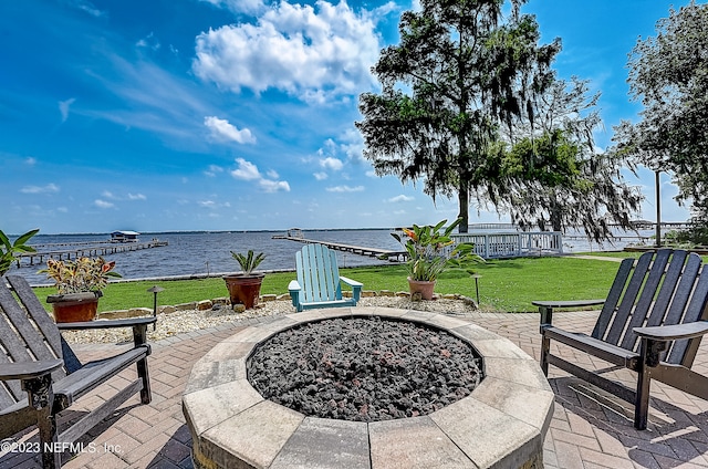 view of patio with an outdoor fire pit and a water view