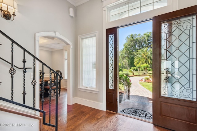 entryway featuring ornamental molding, dark hardwood / wood-style flooring, a healthy amount of sunlight, and coffered ceiling