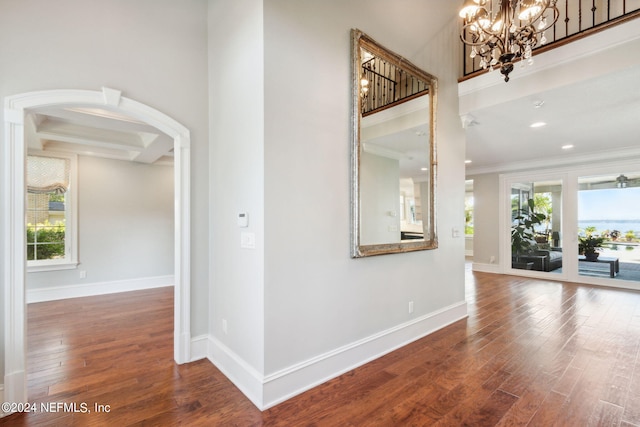 interior space featuring crown molding, an inviting chandelier, dark hardwood / wood-style flooring, and coffered ceiling