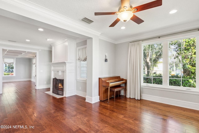 unfurnished living room featuring ceiling fan, crown molding, and dark hardwood / wood-style floors