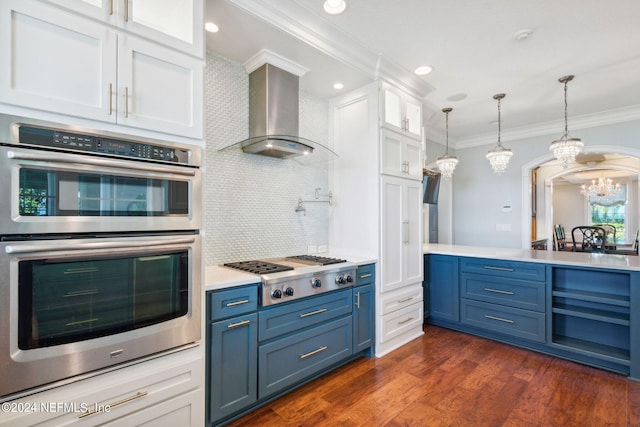 kitchen featuring wall chimney exhaust hood, white cabinets, tasteful backsplash, blue cabinetry, and dark hardwood / wood-style floors