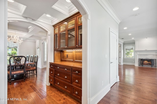 hall featuring coffered ceiling, an inviting chandelier, crown molding, and hardwood / wood-style floors