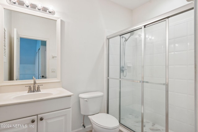 bathroom featuring walk in shower, vanity, and toilet