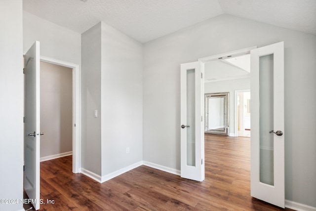 spare room featuring french doors, dark hardwood / wood-style floors, and lofted ceiling