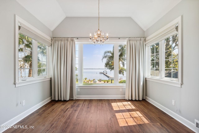 empty room featuring plenty of natural light, dark hardwood / wood-style floors, and a water view