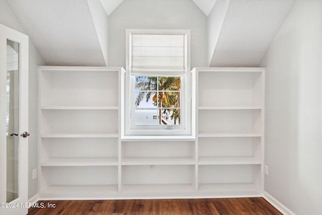 walk in closet with dark hardwood / wood-style flooring and vaulted ceiling