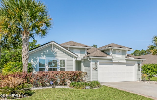 view of front of property with a front yard and a garage