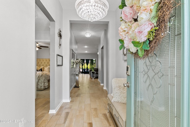 hall featuring light hardwood / wood-style flooring and a chandelier