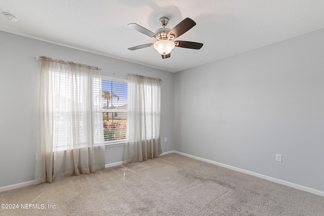 carpeted spare room with ceiling fan