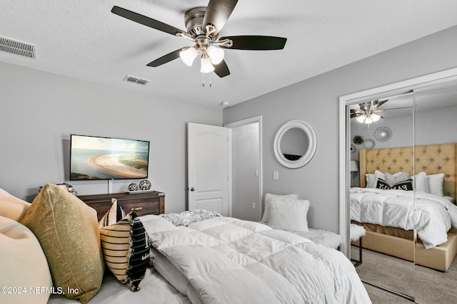 carpeted bedroom with a textured ceiling and ceiling fan