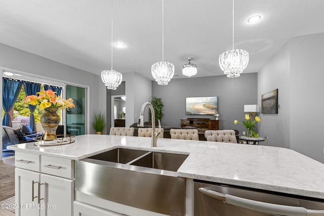 kitchen featuring white cabinetry, an inviting chandelier, hanging light fixtures, wood-type flooring, and light stone countertops