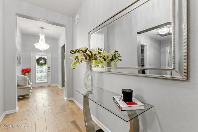 entryway with light wood-type flooring and a chandelier