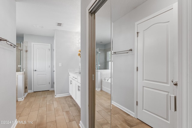 bathroom featuring plus walk in shower, hardwood / wood-style floors, and vanity