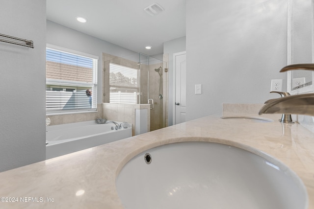 bathroom with double vanity and plus walk in shower