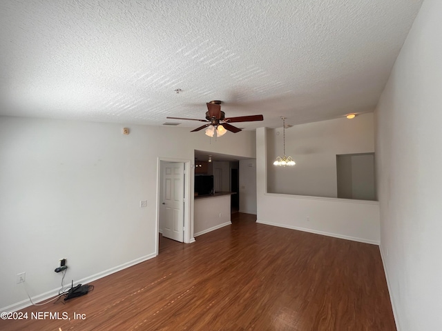 spare room featuring dark wood-type flooring, a textured ceiling, and ceiling fan with notable chandelier