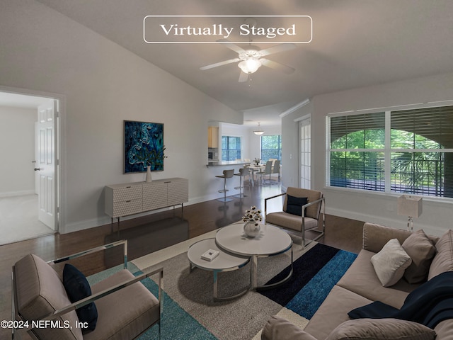 living room featuring hardwood / wood-style floors, ceiling fan, and vaulted ceiling