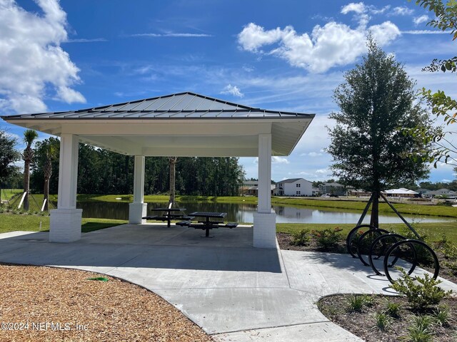 view of community featuring a gazebo, a water view, and a patio area