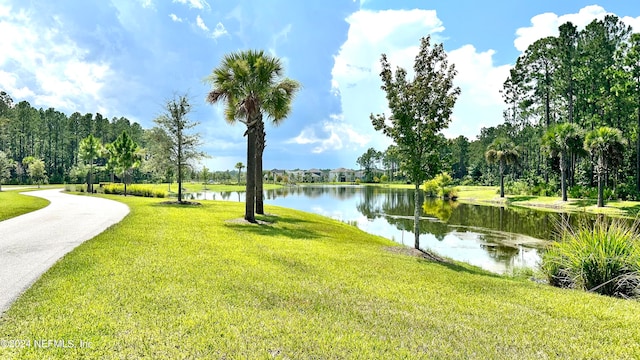 view of home's community with a lawn and a water view