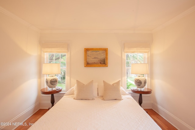 bedroom featuring dark hardwood / wood-style floors, crown molding, and multiple windows