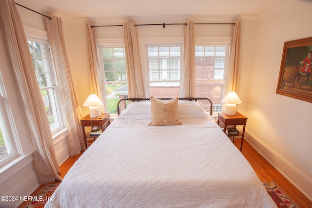 bedroom with crown molding and dark hardwood / wood-style floors