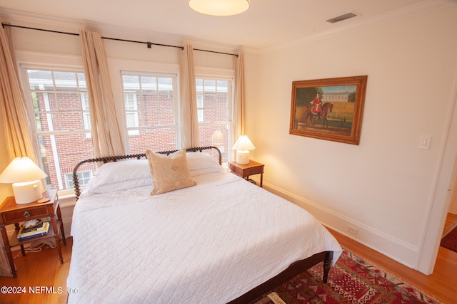 bedroom with wood-type flooring and crown molding