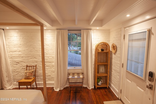 bedroom with beamed ceiling and dark hardwood / wood-style floors