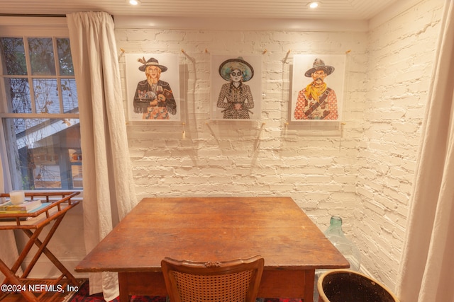 dining area featuring brick wall