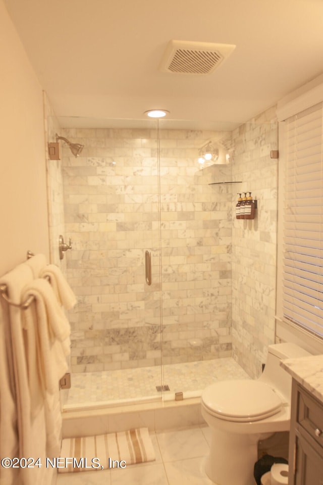 bathroom featuring walk in shower, vanity, tile floors, and toilet