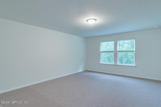 carpeted empty room with a textured ceiling